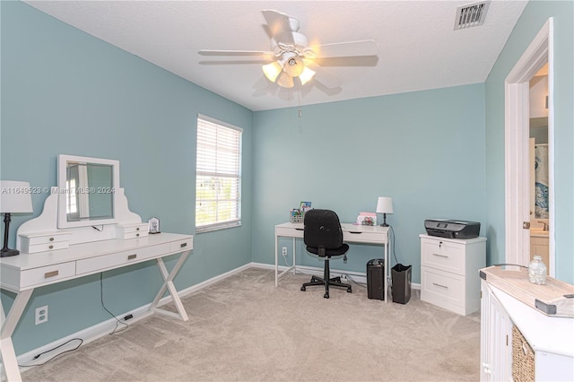 carpeted office space with ceiling fan