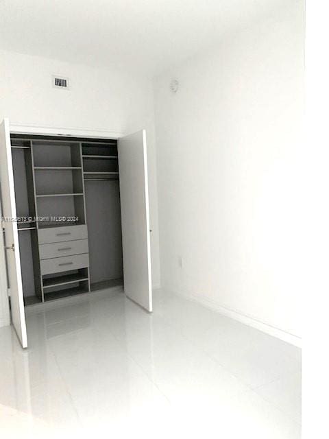 unfurnished bedroom with tile patterned floors and a closet