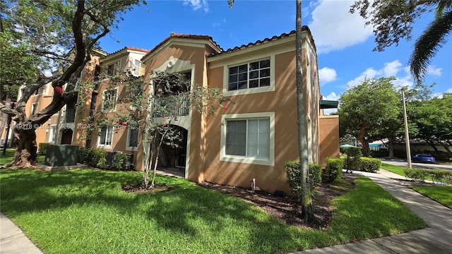 mediterranean / spanish-style house with a balcony and a front yard