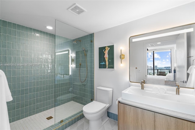 bathroom featuring vanity, toilet, tiled shower, and tile patterned flooring