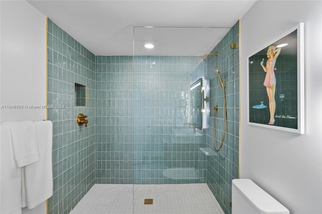 bathroom featuring toilet and a tile shower