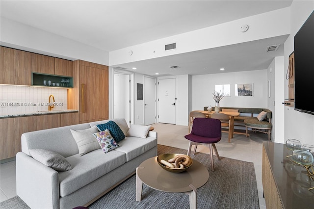 living room featuring sink and light tile patterned flooring