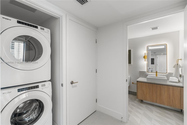 laundry area with stacked washer / dryer and sink