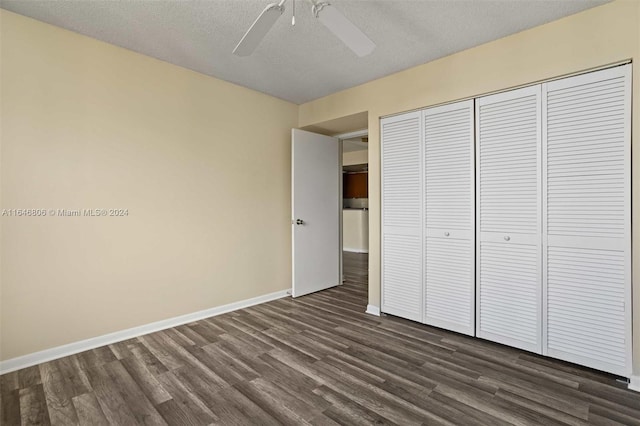 unfurnished bedroom with a textured ceiling, dark hardwood / wood-style flooring, ceiling fan, and a closet