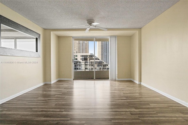 spare room with ceiling fan, dark hardwood / wood-style flooring, and a textured ceiling