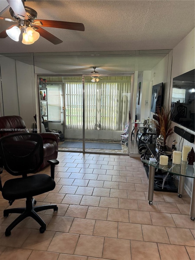 tiled living room featuring ceiling fan and a textured ceiling