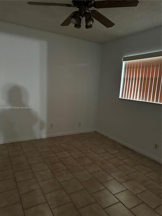 tiled spare room featuring ceiling fan and a textured ceiling