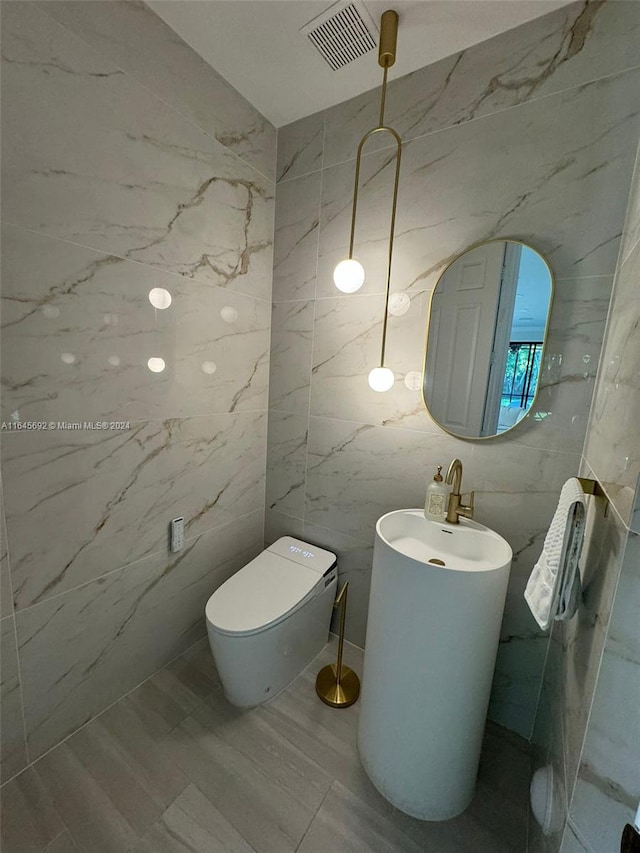 bathroom with tile walls and toilet