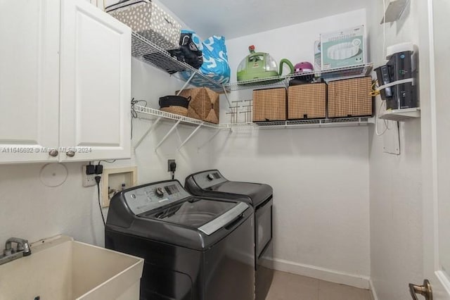 laundry room with cabinets, washer and dryer, and sink