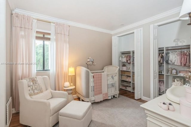 bedroom with a nursery area and ornamental molding