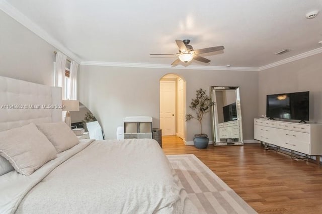 bedroom featuring wood-type flooring, ceiling fan, and crown molding