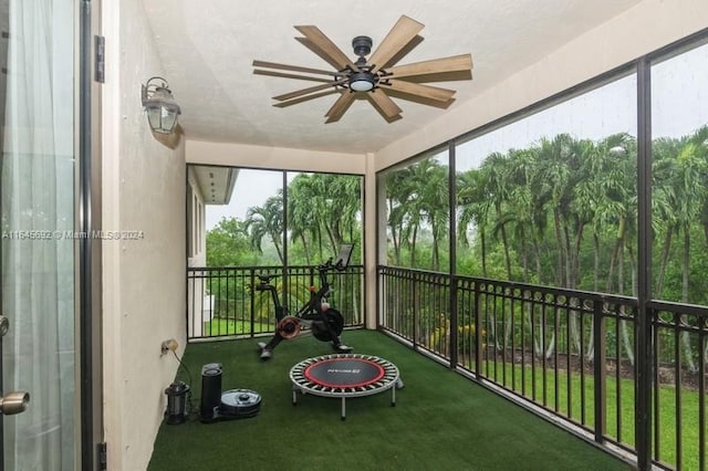 unfurnished sunroom featuring ceiling fan