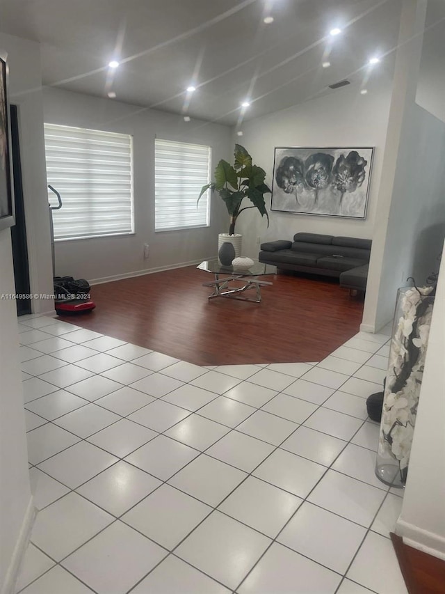 living room with lofted ceiling and tile patterned flooring