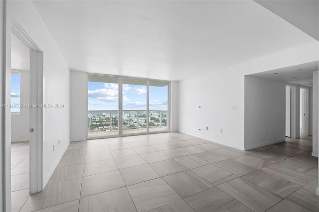 tiled empty room with a wall of windows