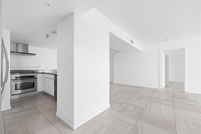 kitchen featuring black dishwasher, wall chimney exhaust hood, stainless steel oven, and white cabinetry