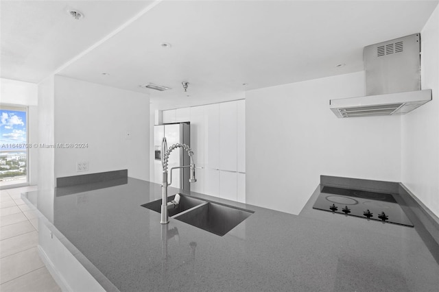 kitchen with white cabinets, stainless steel fridge, sink, ventilation hood, and black electric cooktop