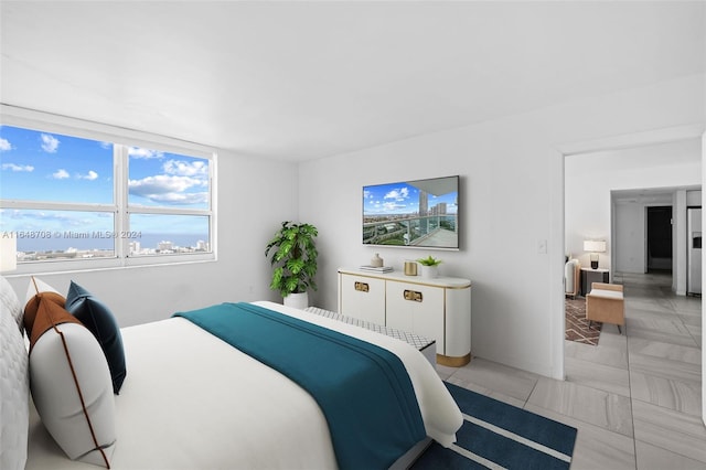 bedroom featuring a water view and light tile patterned floors