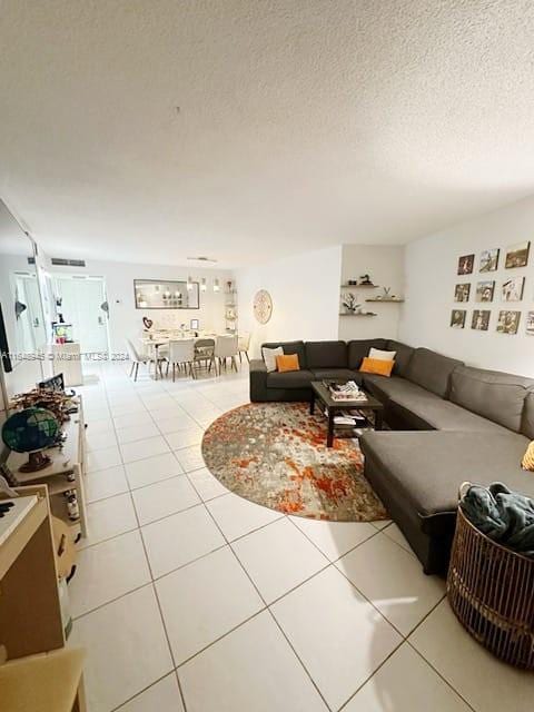 tiled living room featuring a textured ceiling