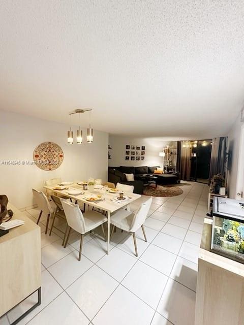 tiled dining space featuring a textured ceiling