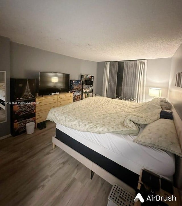 bedroom featuring a textured ceiling and hardwood / wood-style floors