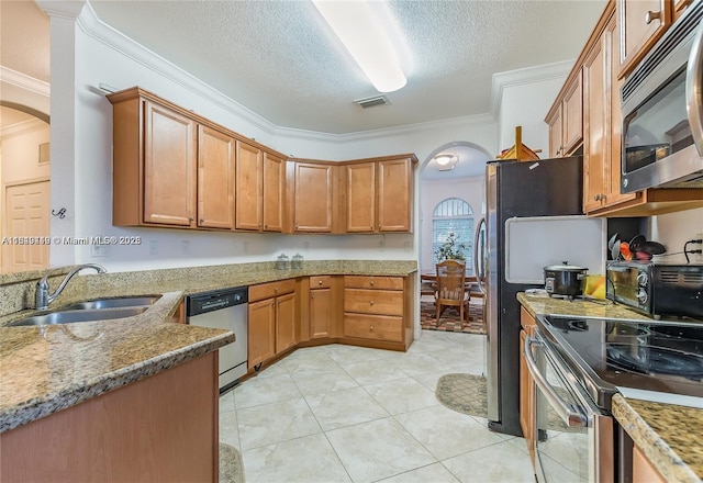 kitchen featuring crown molding, arched walkways, a sink, and appliances with stainless steel finishes