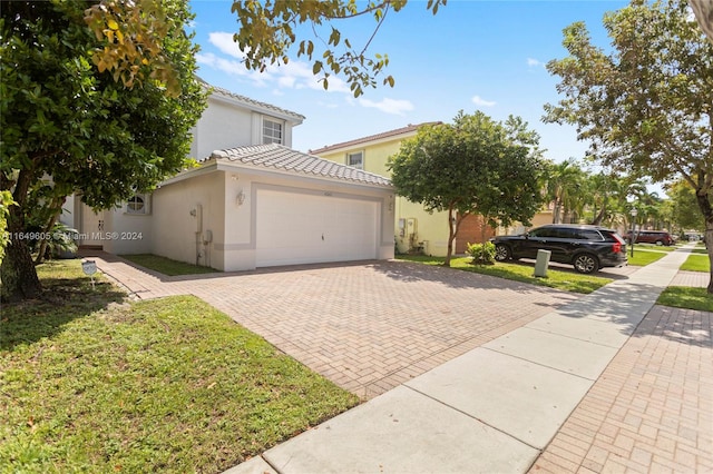 view of front of house with a garage and a front lawn