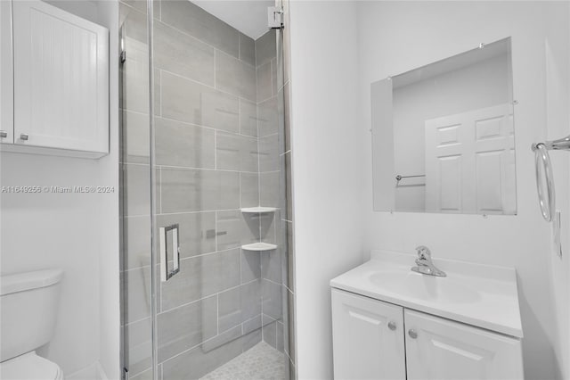 bathroom with walk in shower, toilet, and vanity