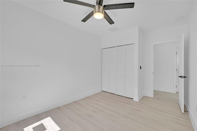 unfurnished bedroom with ceiling fan, a closet, and light hardwood / wood-style floors