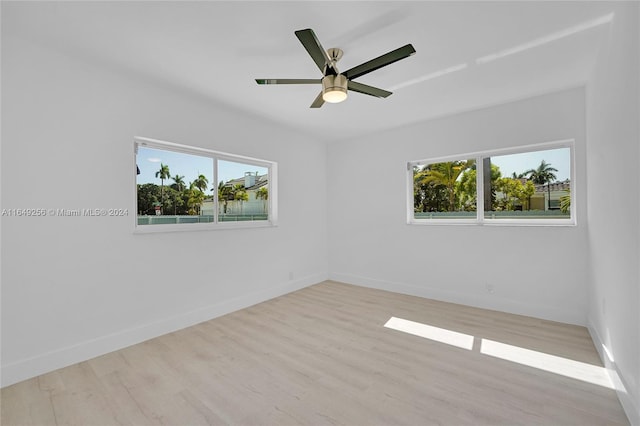 spare room with ceiling fan, plenty of natural light, and light hardwood / wood-style flooring