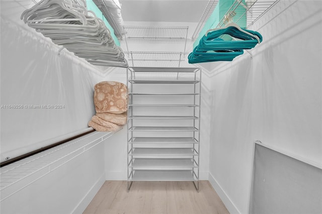 walk in closet with light hardwood / wood-style floors