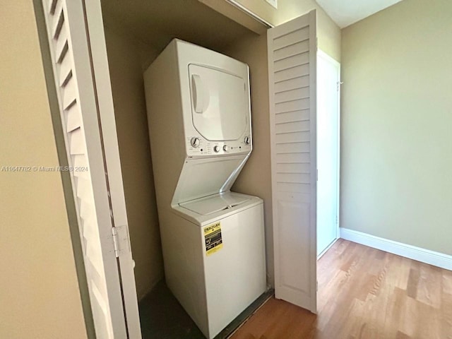 washroom with stacked washer / dryer and light wood-type flooring