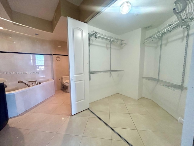 walk in closet with light tile patterned floors