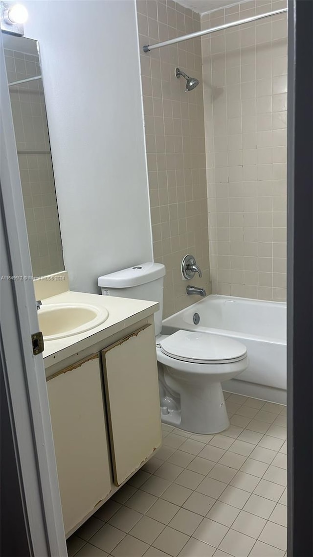 full bathroom featuring tile patterned floors, tiled shower / bath, toilet, and vanity