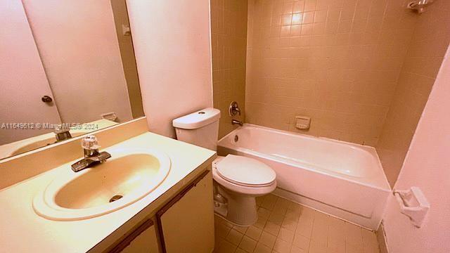 full bathroom with tiled shower / bath, vanity, and toilet