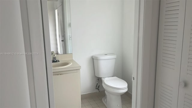 bathroom featuring tile patterned flooring, toilet, and vanity