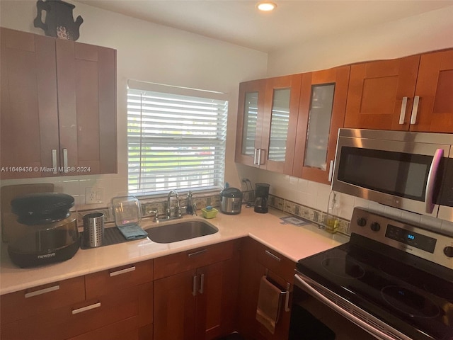 kitchen featuring stainless steel appliances, backsplash, and sink