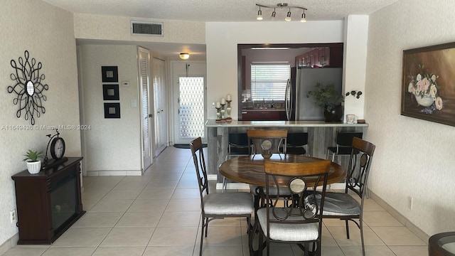 tiled dining area with a textured ceiling