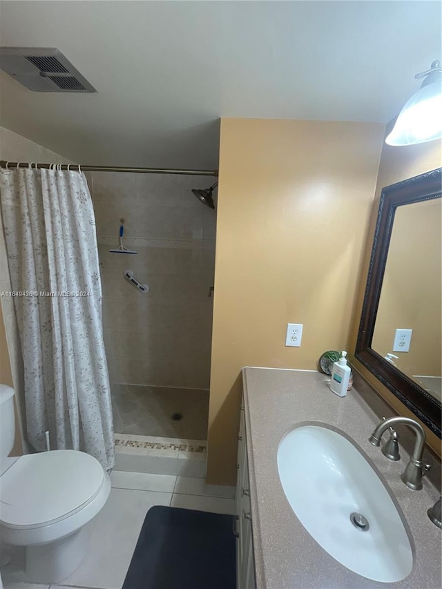 bathroom with tile patterned floors, walk in shower, vanity, and toilet