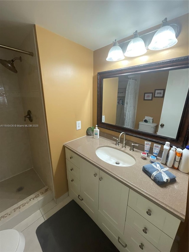 bathroom with tile patterned floors, vanity, toilet, and a stall shower
