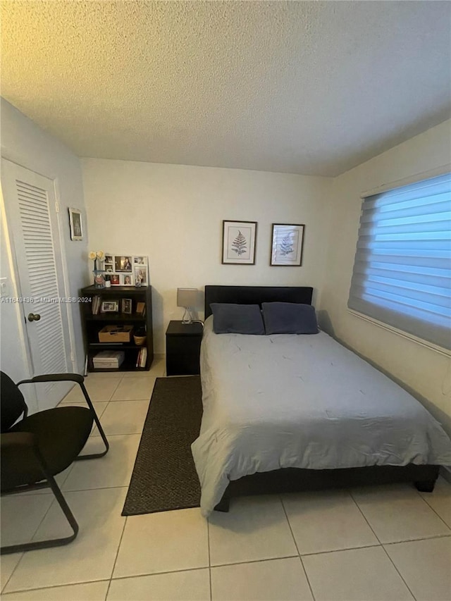 bedroom featuring a textured ceiling and light tile patterned floors