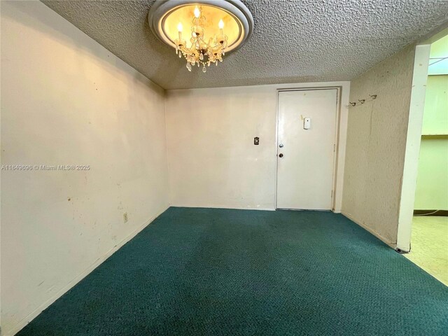 3000 NE 5th Ter Unit 310-A, Wilton Manors, FL 33334 - unfurnished room featuring carpet flooring, a textured ceiling, and a chandelier