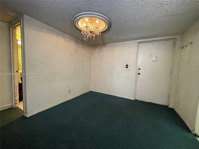 carpeted spare room with a textured ceiling and an inviting chandelier