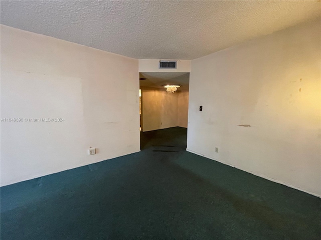 empty room featuring a textured ceiling and carpet