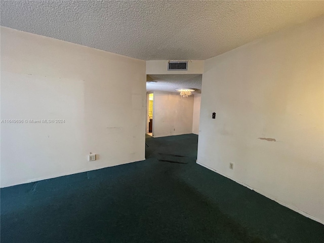 carpeted spare room with a textured ceiling