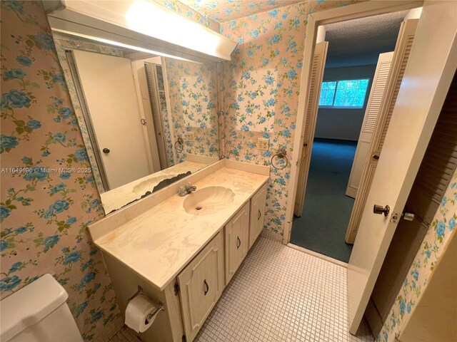 3000 NE 5th Ter Unit 310-A, Wilton Manors, FL 33334 - half bath featuring vanity, wallpapered walls, and tile patterned floors