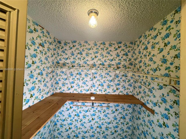 3000 NE 5th Ter Unit 310-A, Wilton Manors, FL 33334 - bedroom with wallpapered walls and a textured ceiling