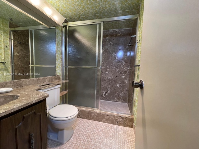 bathroom featuring vanity, toilet, an enclosed shower, and tile patterned floors