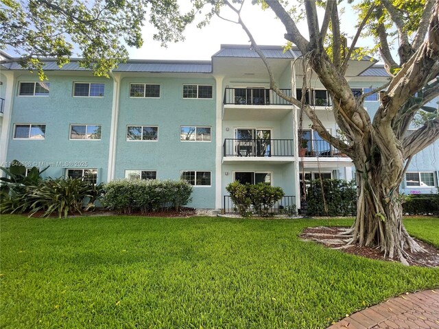 3000 NE 5th Ter Unit 310-A, Wilton Manors, FL 33334 - rear view of property with a yard, a metal roof, and stucco siding