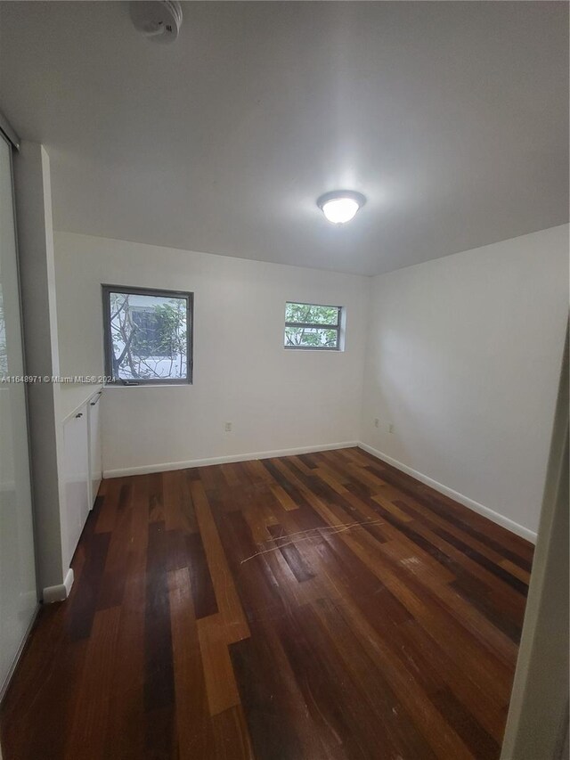 empty room with dark wood-type flooring