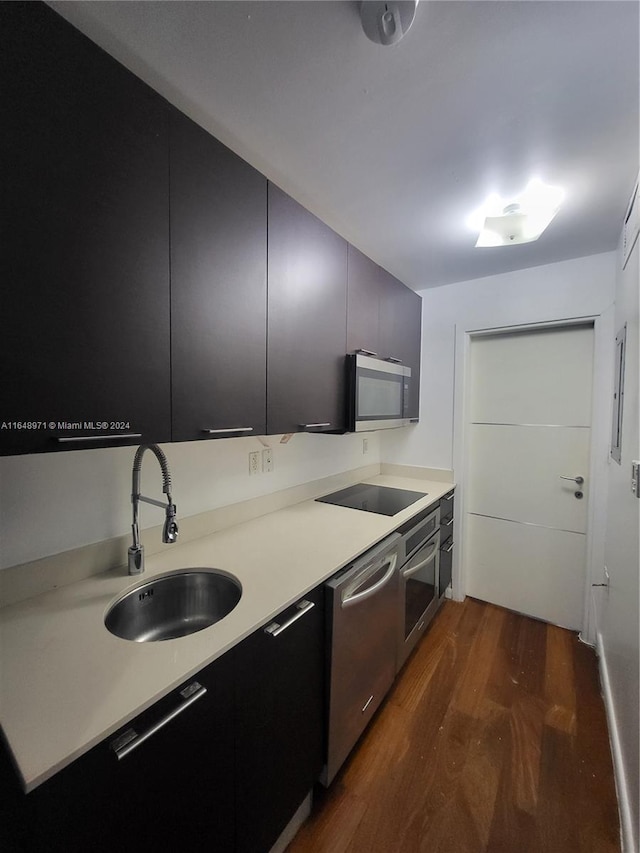 kitchen featuring dark hardwood / wood-style floors, stainless steel appliances, and sink